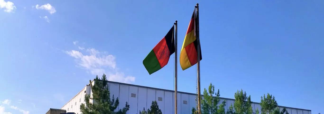 flags of afghanistan and germany outside of a building