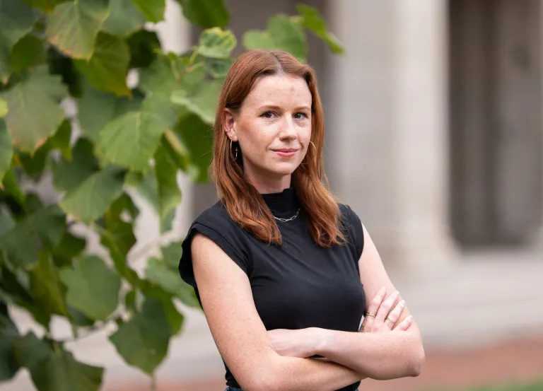woman wearing a black shirt standing near a tree
