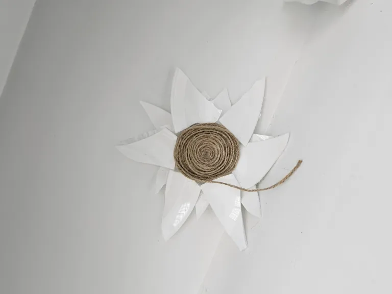 Shards of white ceramic encircle a coil of twine