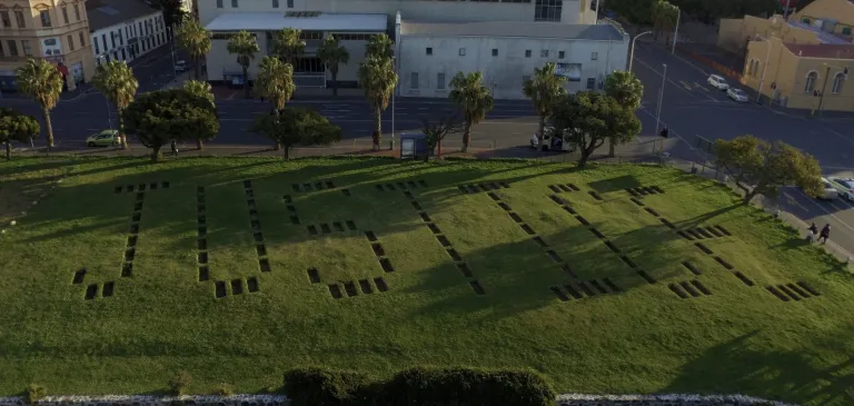 coffin-size holes form letters to spell out the word justice