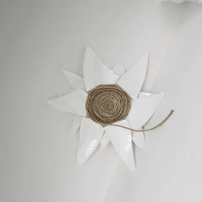 "Shards of white ceramic encircle a coil of twine"